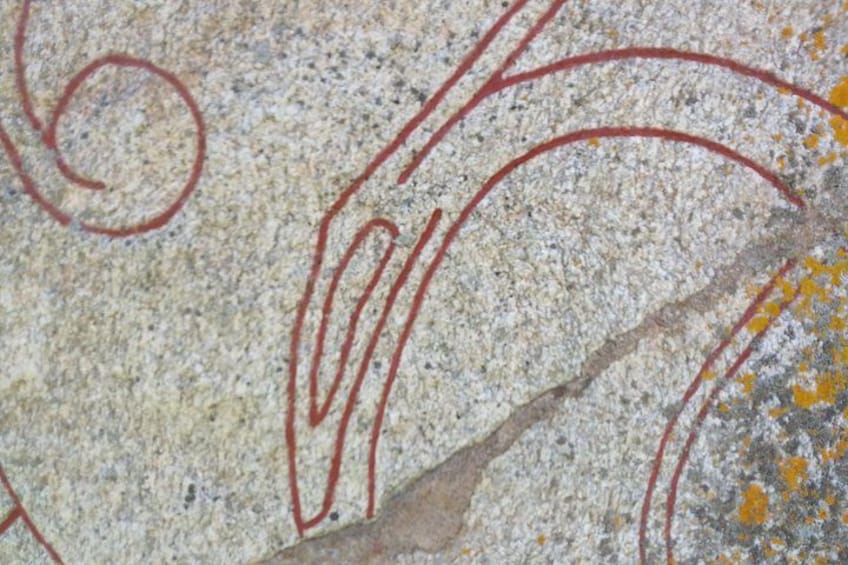 A close-up of a stone surface with red and yellow markings. 2