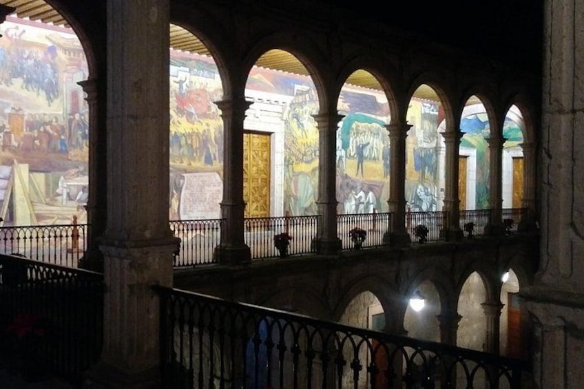 An interior with arched ceilings, columns, and a balcony with a railing. 2