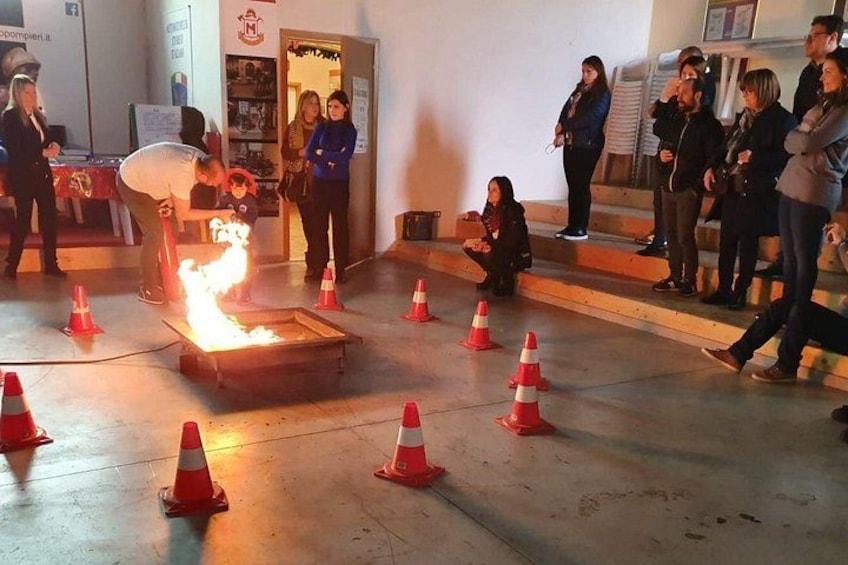 Eine Feuervorführung mit einem Künstler und einem Feuerkorb, umgeben von orangefarbenen Absperrkeilen. 3