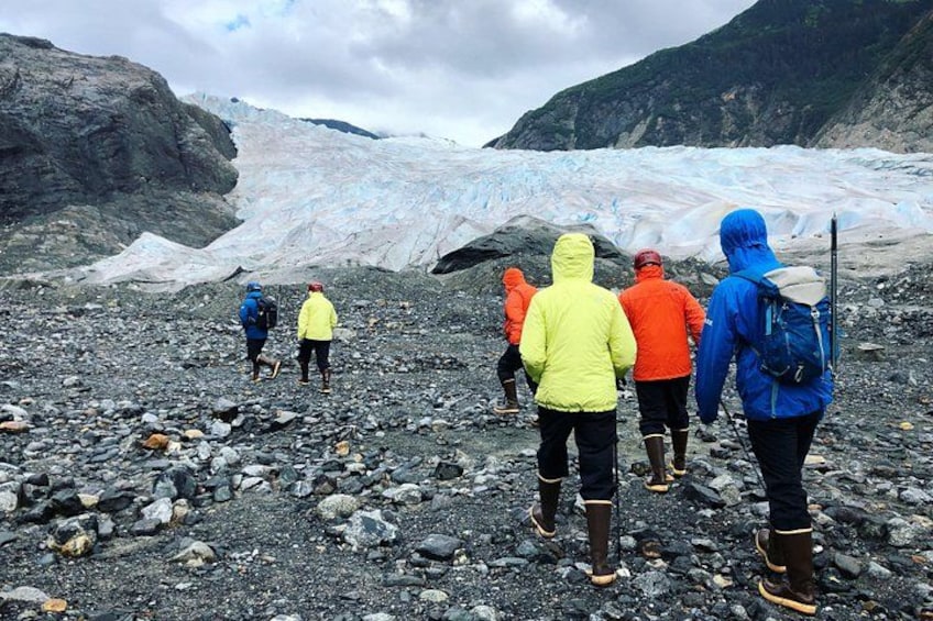 Un groupe de randonneurs sur un terrain rocheux, avec un glacier en arrière-plan. 3