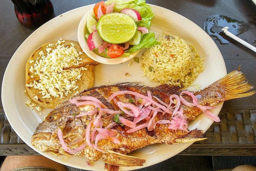 A plate with grilled fish, rice, and a side salad. 3