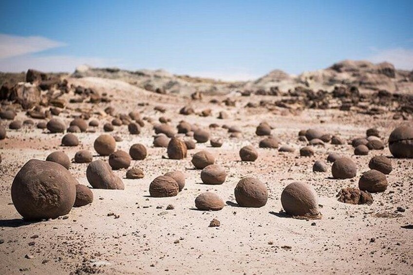 A desert landscape with numerous spherical rock formations. 4