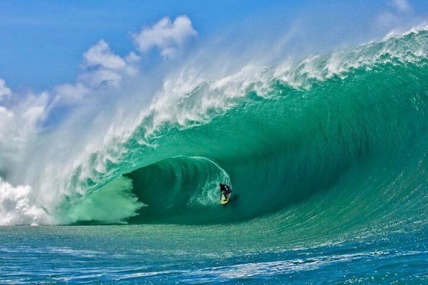 A surfer riding a large wave in the ocean. 5