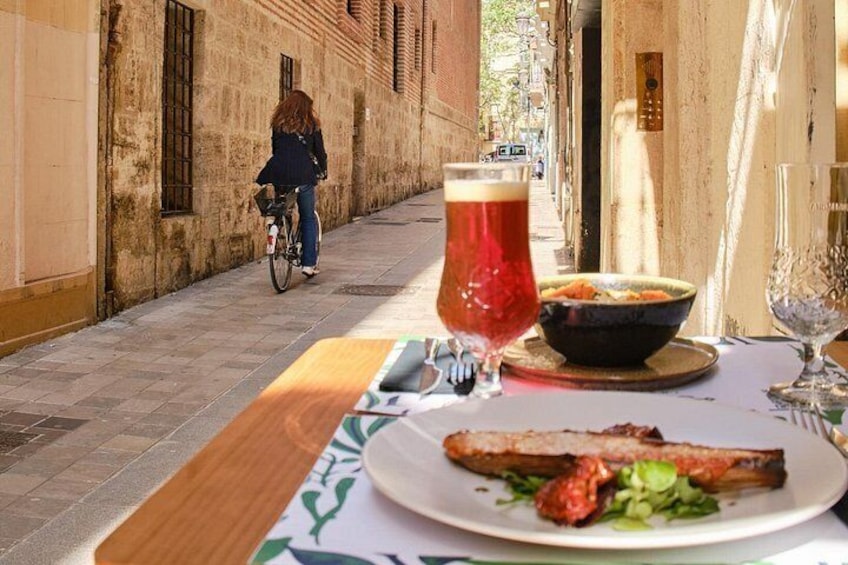 A table with a plate of food, a glass of beer, and a bowl of soup. 5