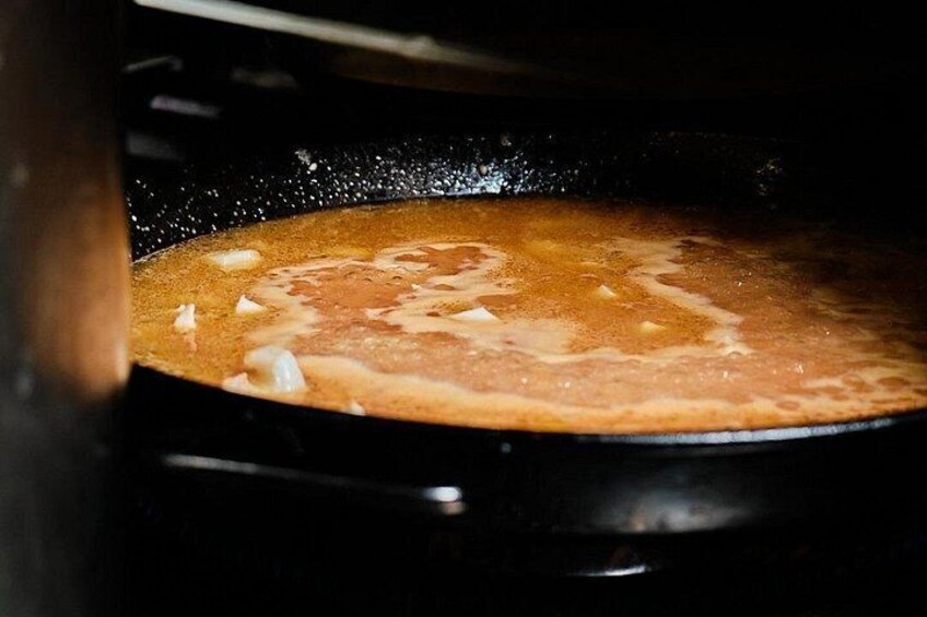 A pan with a bubbling liquid, likely a soup or sauce, inside an oven. 3