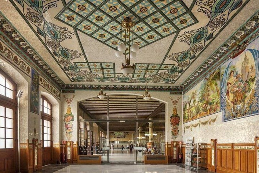 A grand hall with ornate ceiling, large windows, and detailed murals. 1