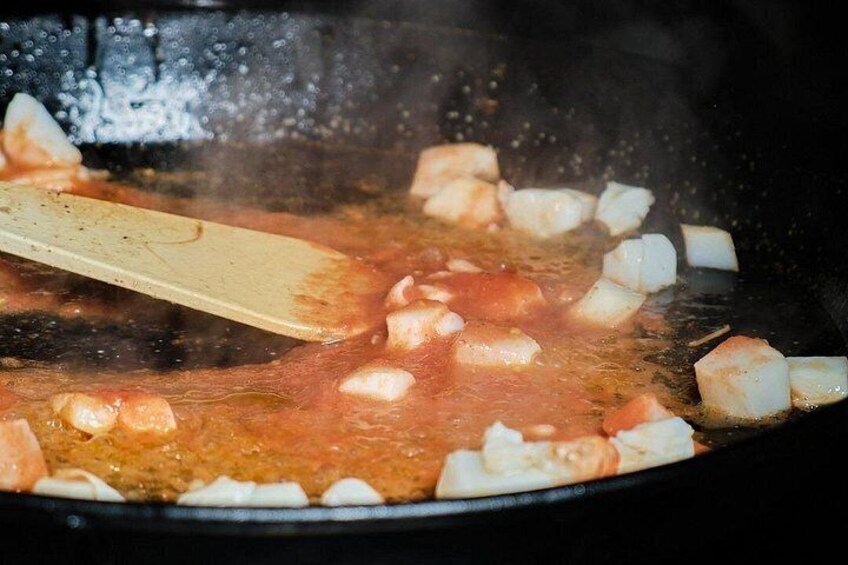 A pan with diced white and red ingredients being stirred. 4