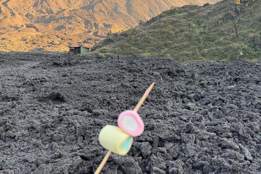 A wooden skewer with colorful candies against a backdrop of a volcanic landscape. 4