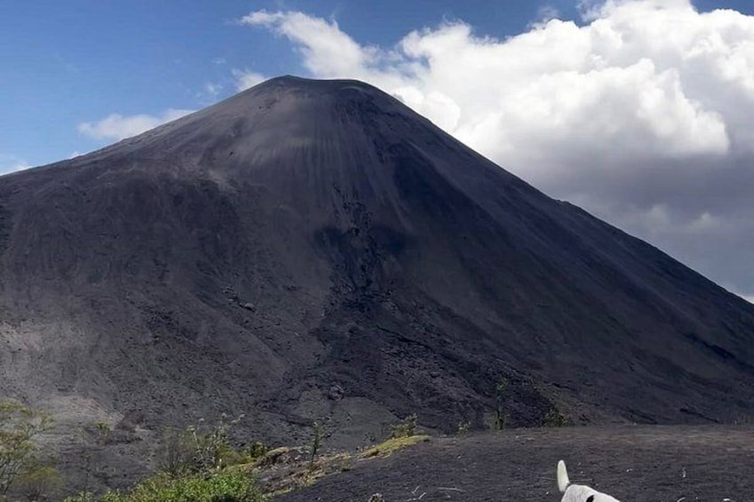 A large, dark mountain with a clear sky and clouds. 3
