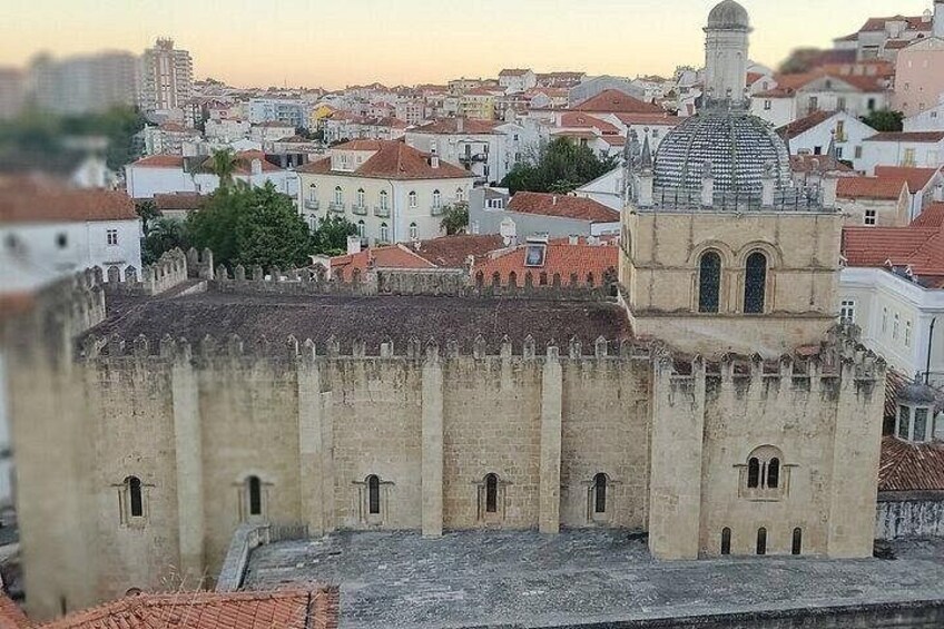 A historic fortification with a dome-topped tower, surrounded by a cityscape with red-roofed buildings. 4
