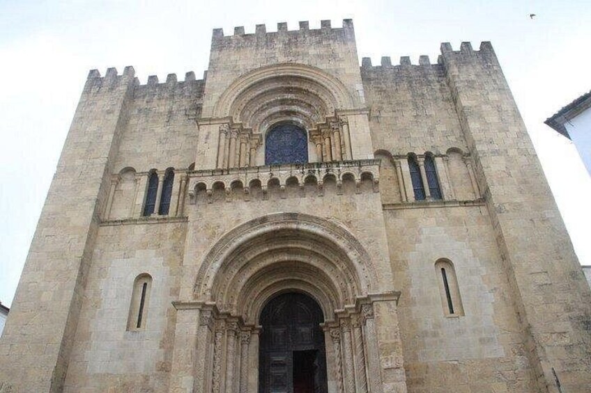 A large stone cathedral with a central arched entrance, flanked by two smaller arches, and a large circular window above the entrance. 5