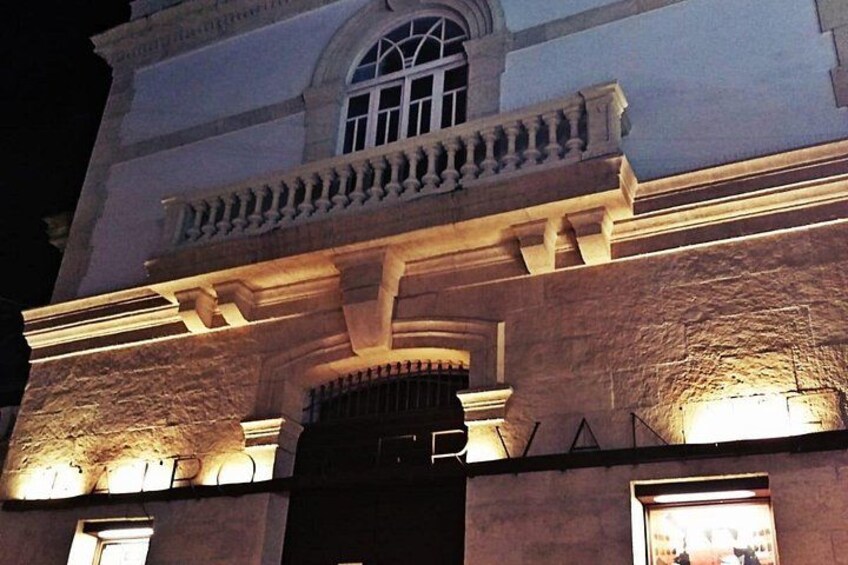 Un edificio de arquitectura clásica, con un balcón con barandilla y un amplio ventanal de arco. 5