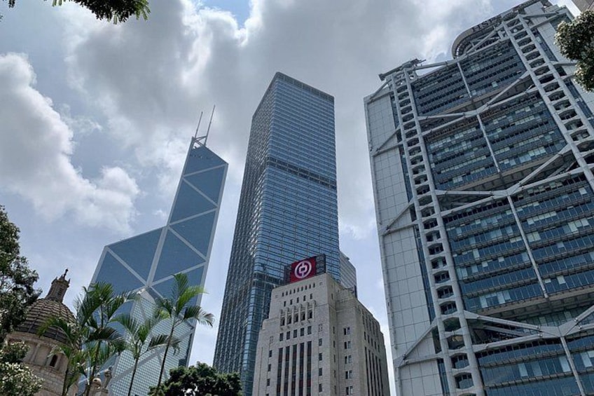 A cityscape with modern skyscrapers, palm trees, and a cloudy sky. 2