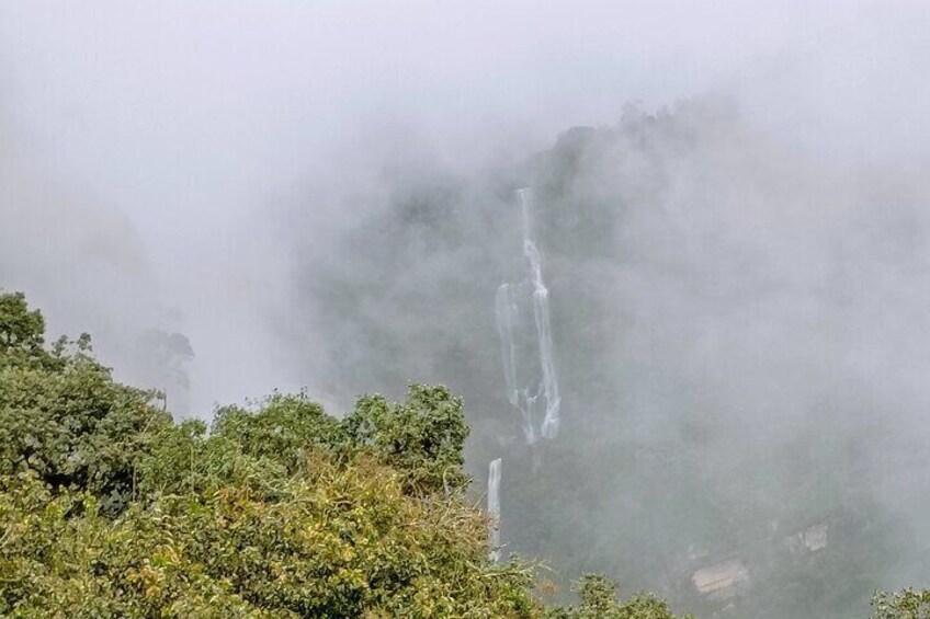 A waterfall surrounded by mist and dense foliage. 5