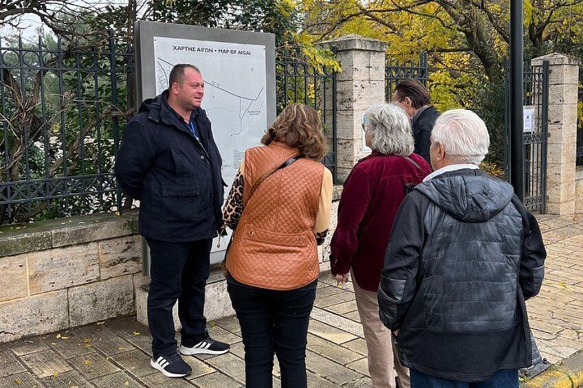 A group of people standing near a map sign outdoors. 1
