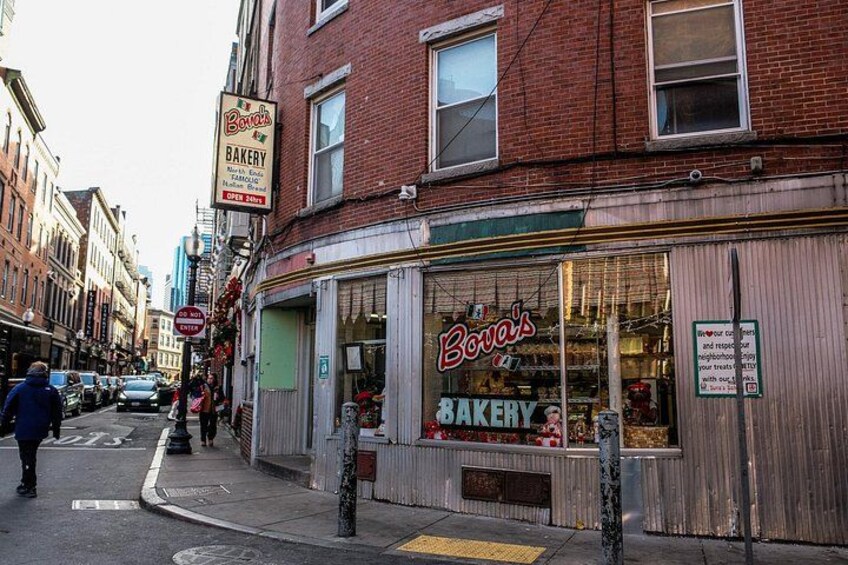 En gade med et bageri ved hjørnet, bageriet hedder 'Bova's Bakery'. 2