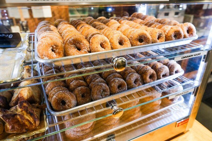 Un expositor con diferentes productos horneados, como donas y pasteles. 2