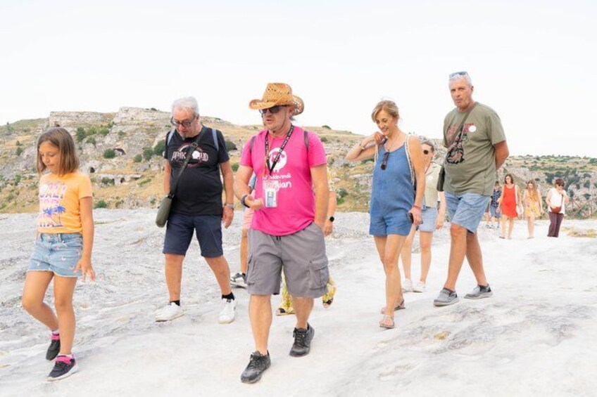 A group of people walking on a rocky path with a hilly landscape in the background. 5
