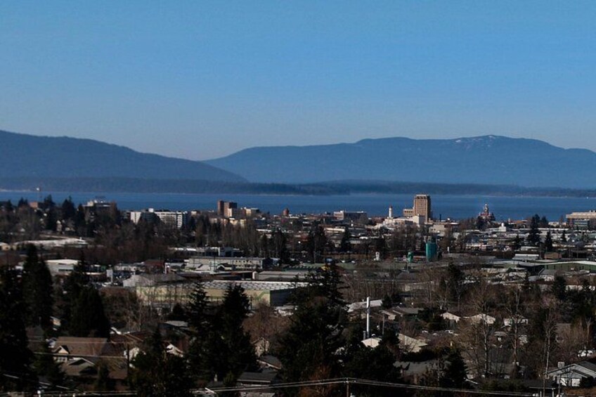 A cityscape with a large body of water, mountains in the background, and a prominent building in the center. 4