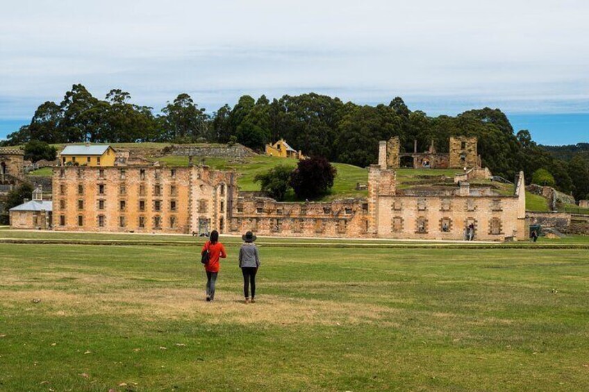 A historic building complex with ruins and a large lawn. 3