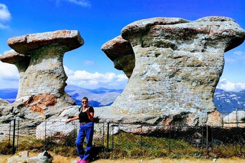 Una persona de pie frente a formaciones rocosas, con un paisaje montañoso al fondo. 4