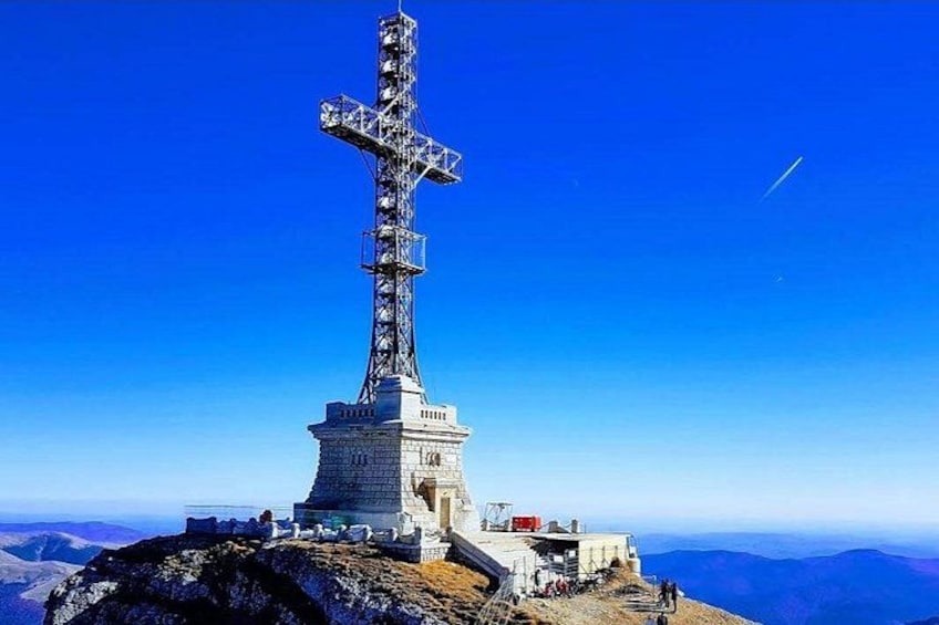 Una alta estructura cruciforme en la cima de una montaña con cielo despejado. 1
