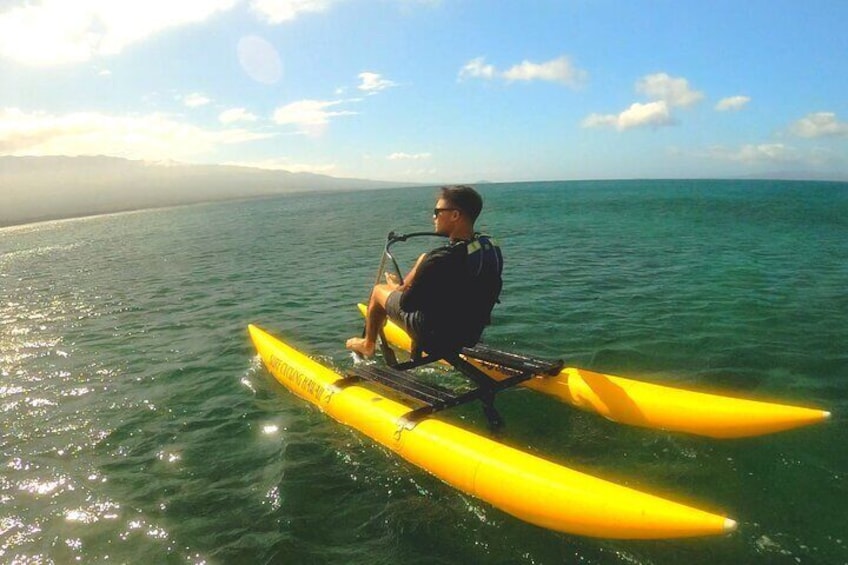 A person kayaking on a yellow board in calm ocean waters. 3