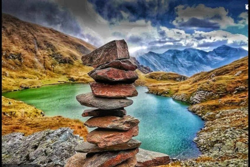 Een stapel rotsen in een bergachtig landschap met een meer. 4