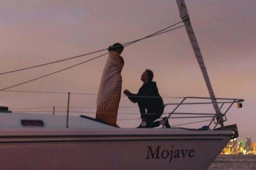 Un velero llamado 'Mojave' con una persona de pie en la cubierta y otra sentada. 3