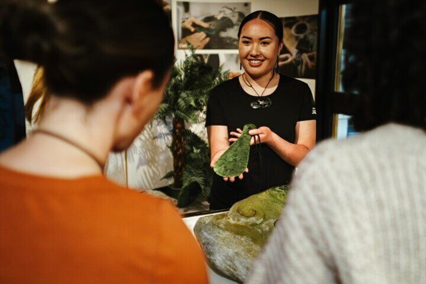 A person holding a green leaf in an indoor setting with plants and a window in the background. 5
