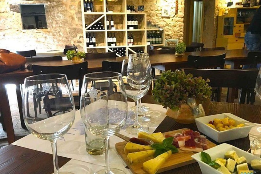 A restaurant interior with wine glasses, a fruit platter, and a wine rack in the background. 2