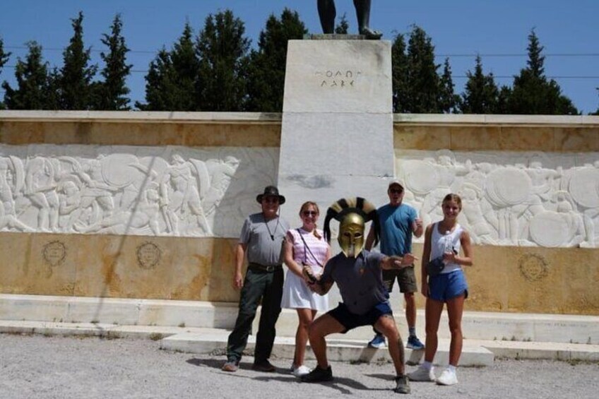 Un groupe de personnes posant devant un monument orné d’une sculpture en relief et d’un piédestal portant des inscriptions. 4