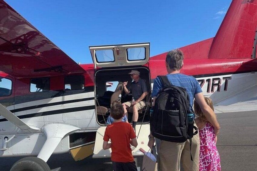 A small aircraft with passengers boarding. 2