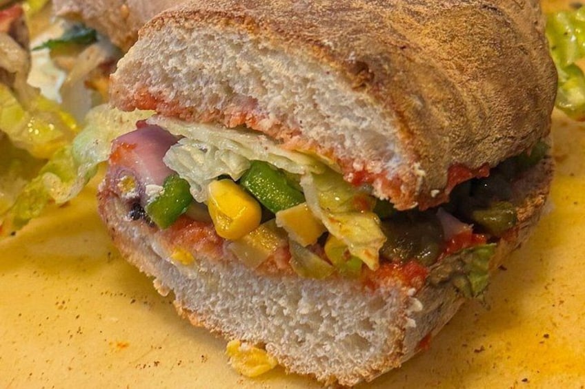 A sandwich with visible ingredients like lettuce, tomato, and corn. 4