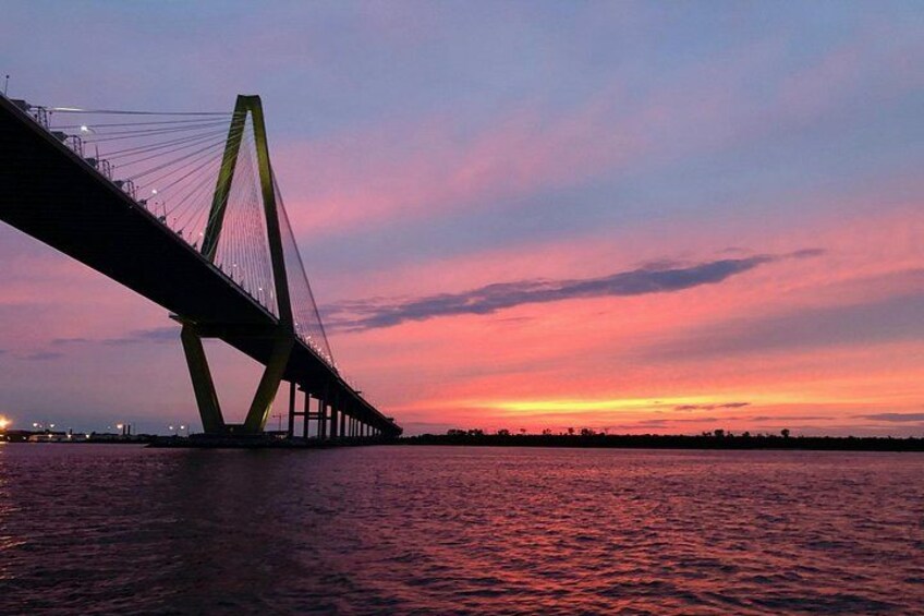 A bridge at sunset with a pink sky. 2