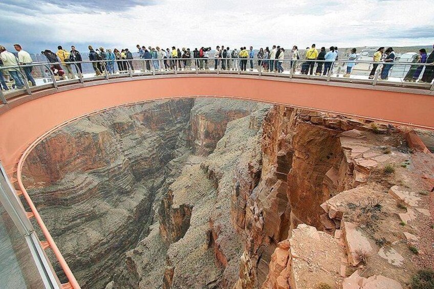 A large canyon with a viewing platform and people observing. 2