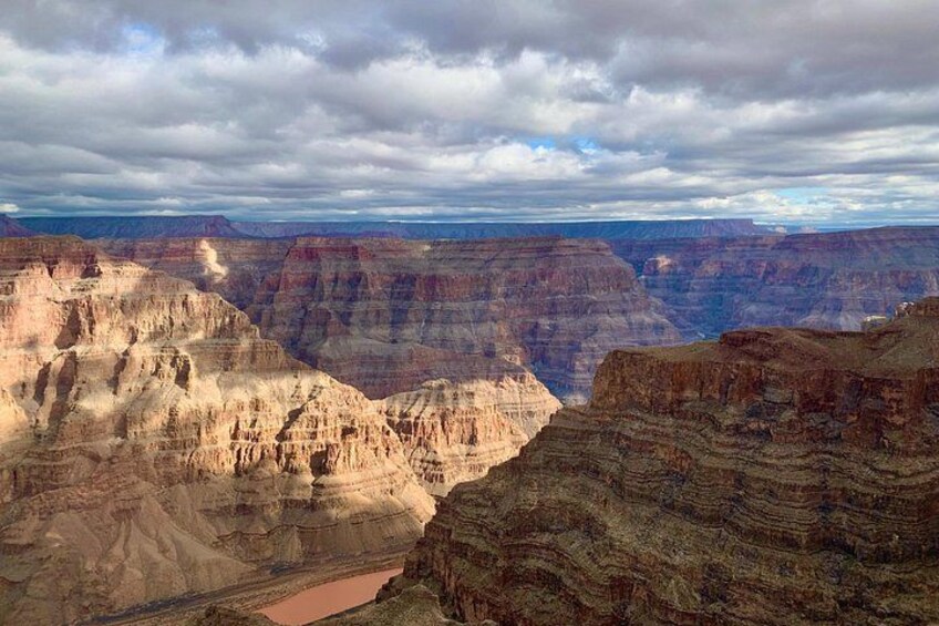 A canyon with layered rock formations and a river. 5