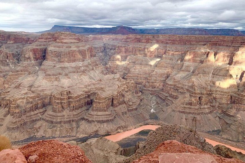 A canyon with layered rock formations and a winding river. 4