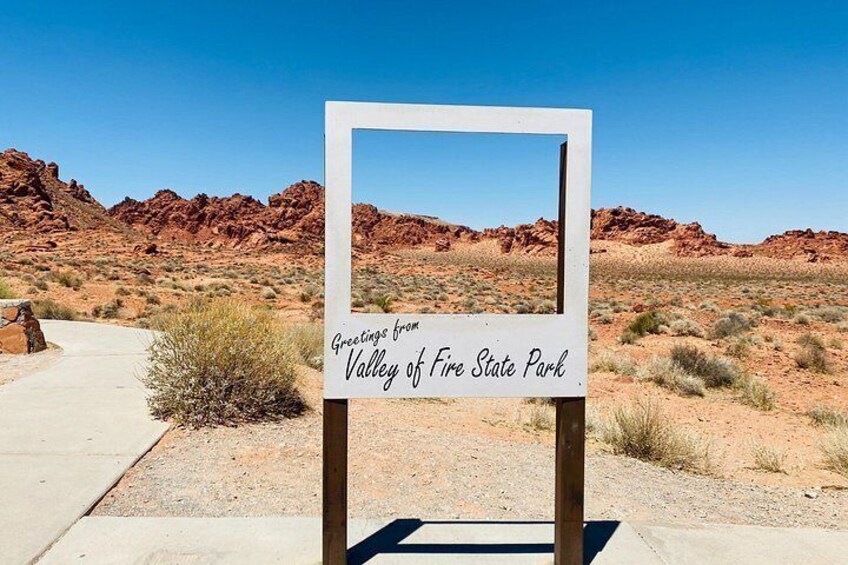 A sign with a desert landscape in the background. 2