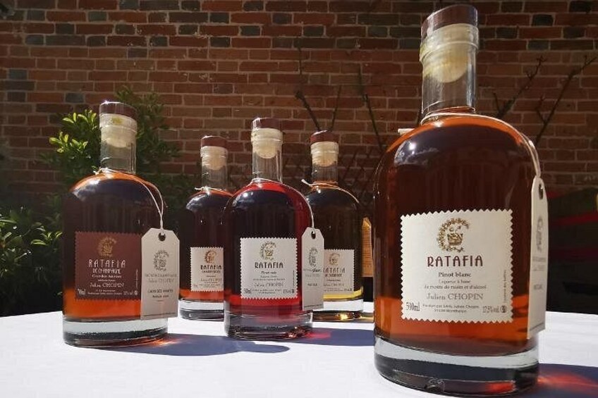 Bottiglie di vino Ratafia su un tavolo con un muro di mattoni sullo sfondo. 3