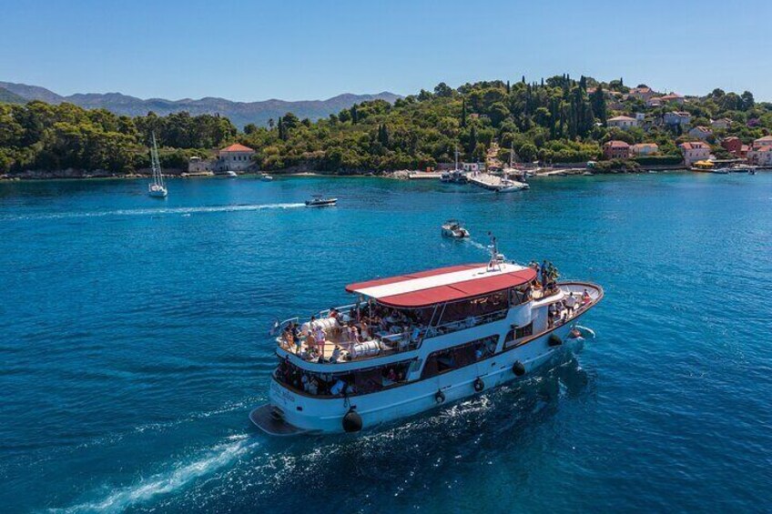 A white boat with a red roof sailing on a blue body of water. 4