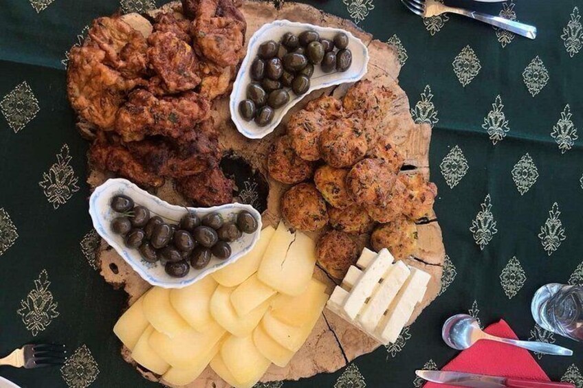 A charcuterie board with various meats, olives, cheese, and crackers. 4