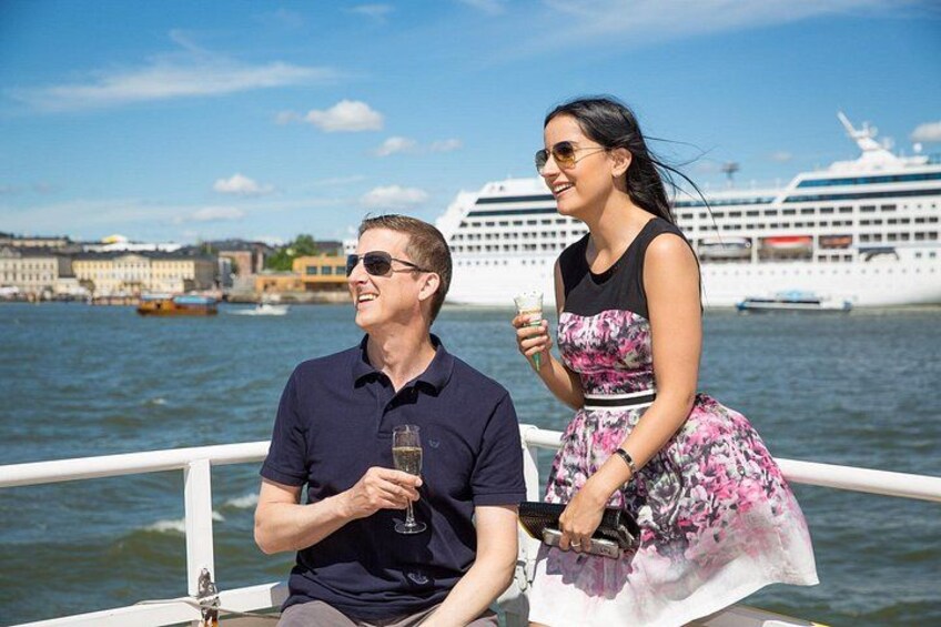 A couple on a boat with a cruise ship in the background. 2
