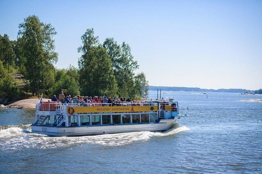Ein Ausflugsboot mit Passagieren auf einem Fluss, umgeben von Bäumen und blauem Himmel. 4