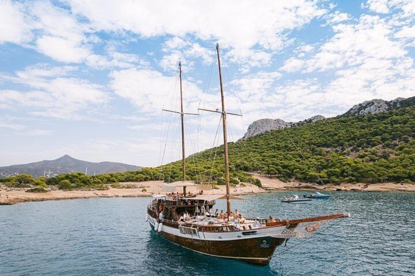 A sailboat on calm waters with a mountainous backdrop. 1