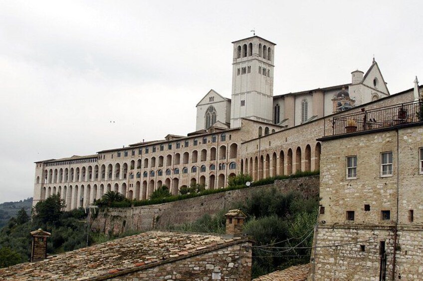 A large historic building with multiple arches and a bell tower. 1