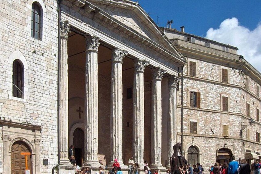A historic building with large columns and a cross, surrounded by people. 4