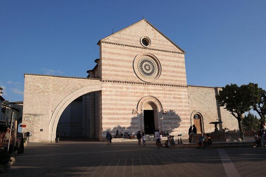 A large stone building with a prominent arched entrance and a circular window. 3