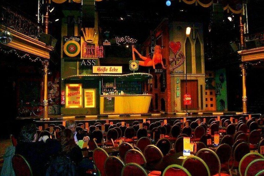 A theater with a stage, audience seating, and a bar named 'Heipa Eek'. 5