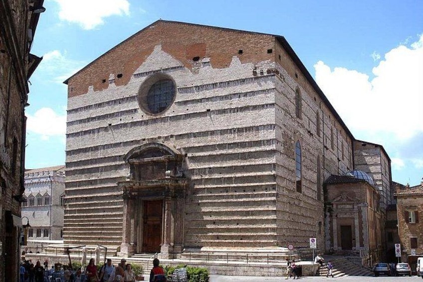 A historic building with a prominent arched entrance and a circular window. 3